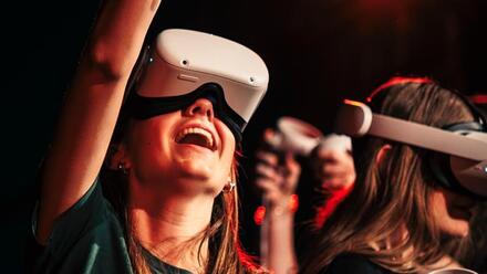 iemand met een vr bril en haar arm omhoog met een afstandsbediening in haar hand
