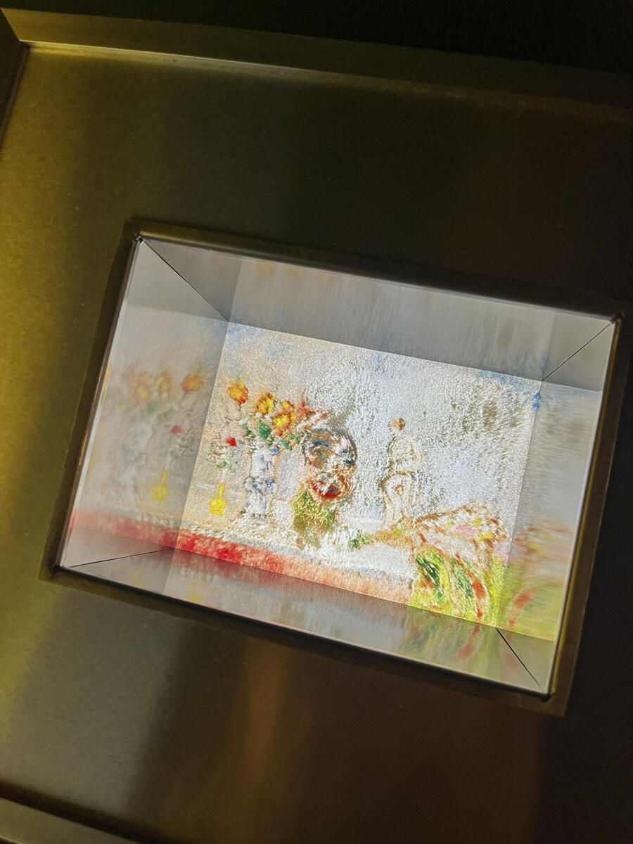Een afbeelding van het schilderij van James Ensor in een glazen doos met reflecties.