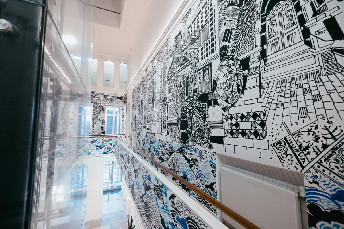 De balustrade van de Fundatie, met rechts een grote muur illustratie in zwart-wit en blauw
