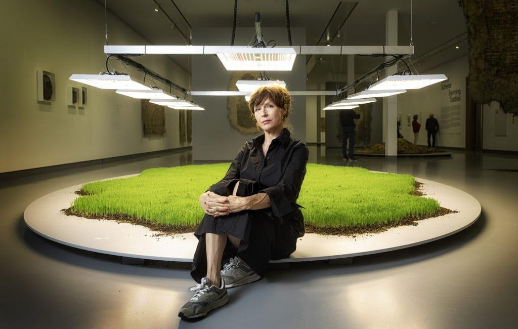 Diana Scherer zit de rand van een van haar installaties: een grasmat middenin een atelier. 