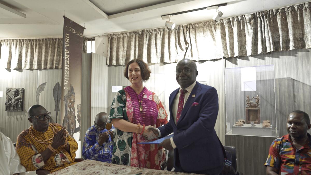 De bestuurder van de Fundatie schudt handen met M. Babatunde Adebiyi bij de offici&euml;le ondertekening van het restitutiedocument.
