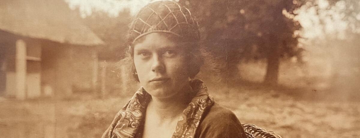 Een oude portretfoto van B&eacute; Thoden van Velzen. Ze draagt een kapje en kijkt de camera in.