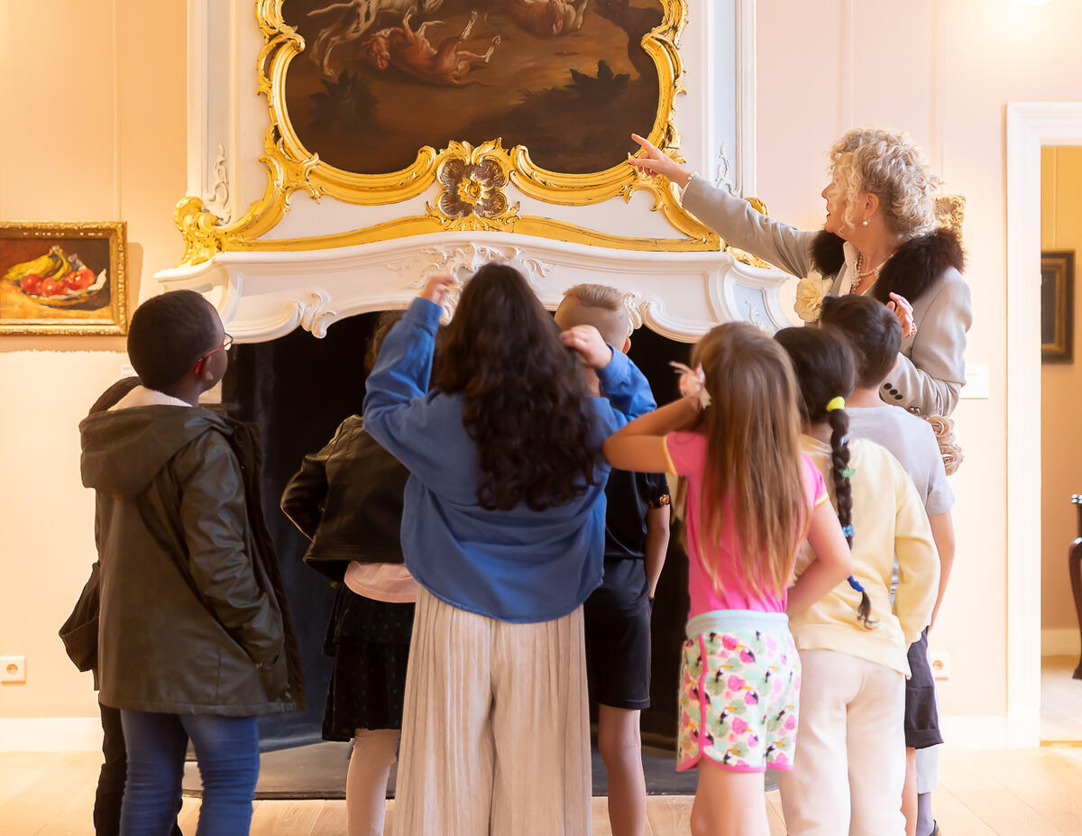 Kinder stehen in einer Gruppe und betrachten ein Gem&auml;lde im Kasteel het Nijenhuis.