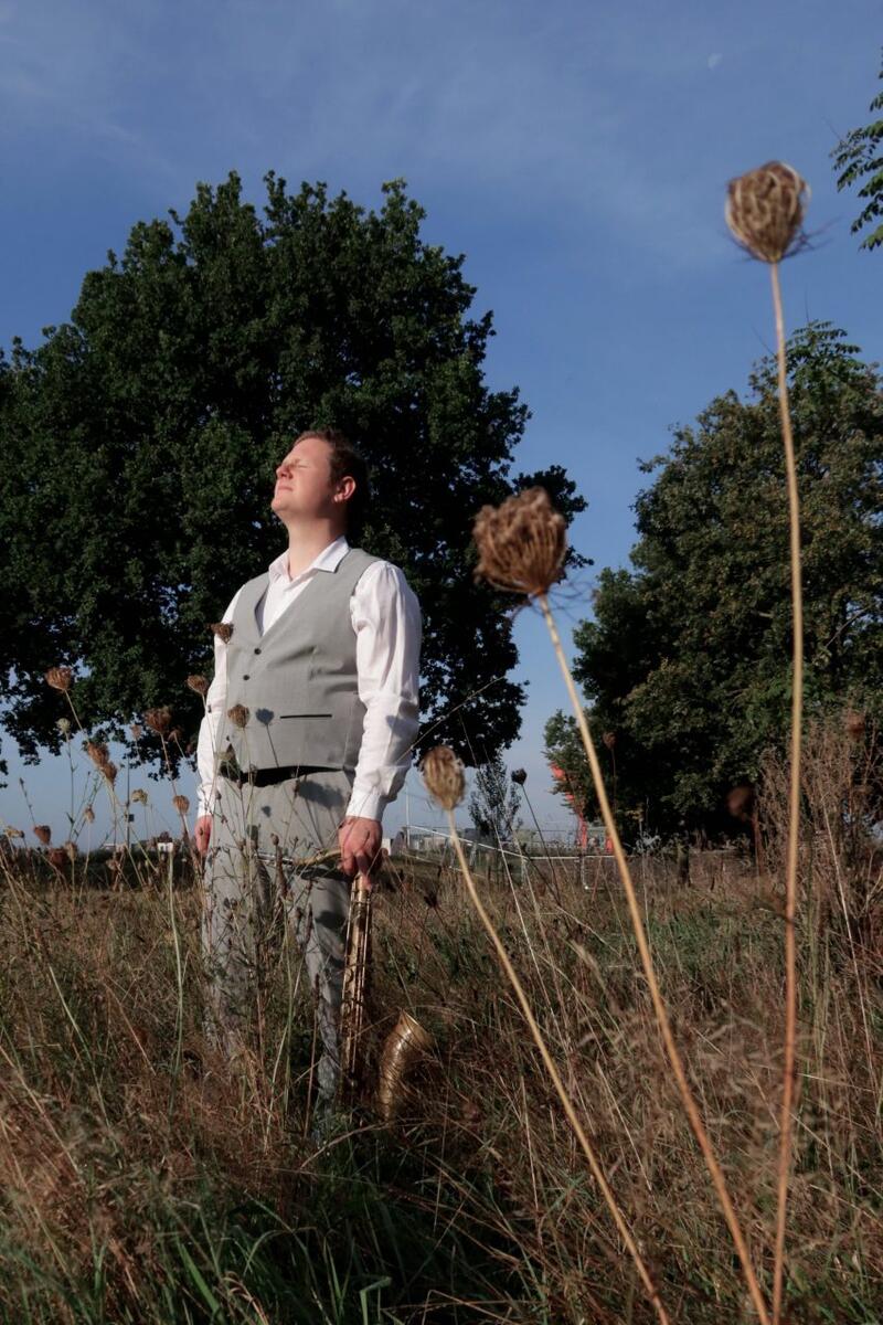 Gerben Wasser in een veld met op de achtergrond 2 bomen en een blauwe lucht