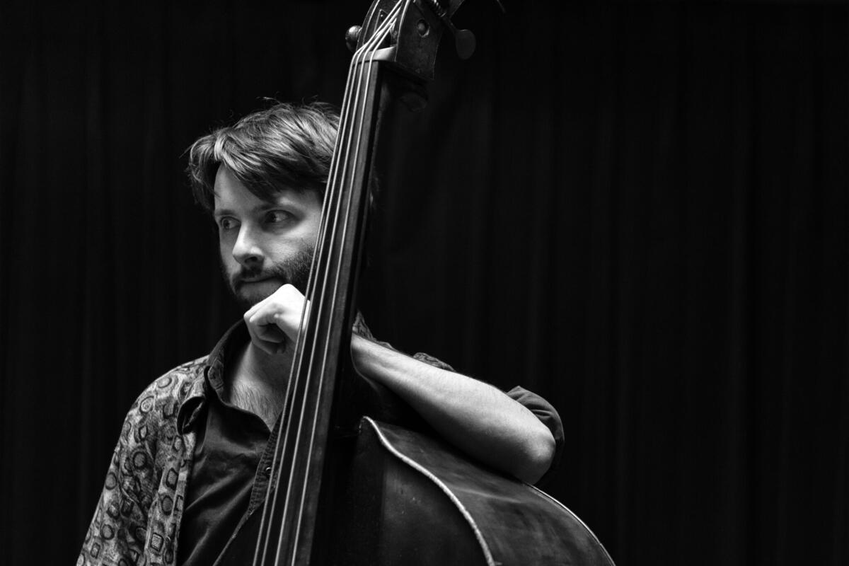 Zwart-wit potretfoto van Tijs Klaassen met zijn basgitaar