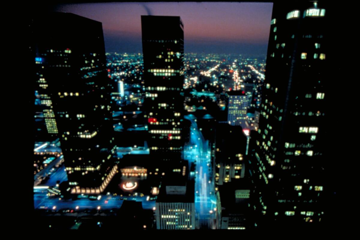 Ein Standbild aus dem Film &bdquo;Koyaanisqatsi&ldquo;, das eine Stadt mit Wohnblocks aus der Vogelperspektive zeigt