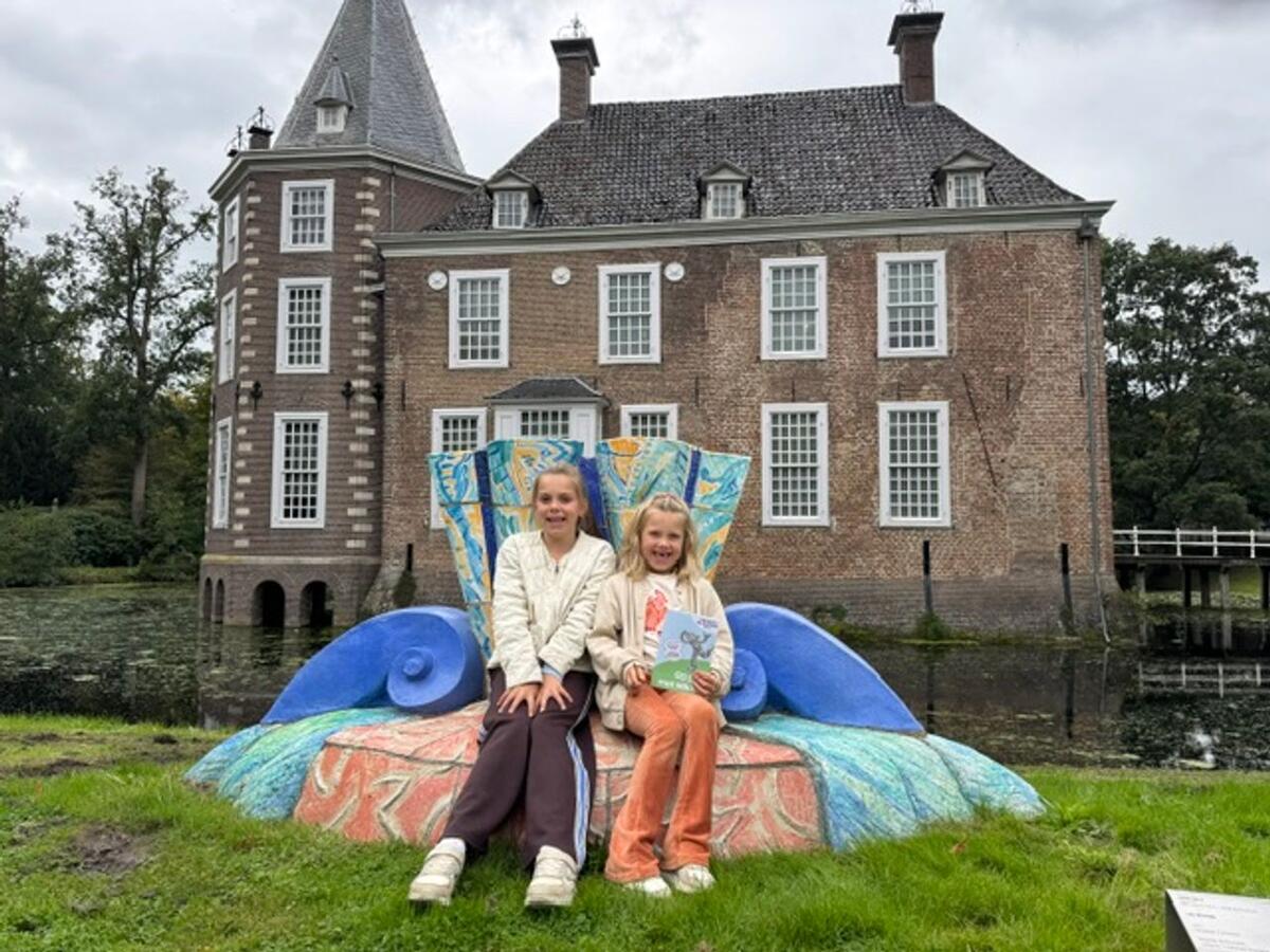 Twee kinderen zittend op een kunstwerk in de beeldentuin van Museum de Fundatie Heino