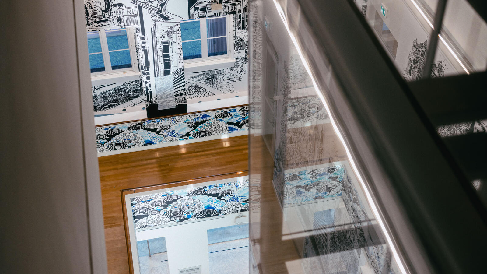 Van bovenaf kijk je in deze foto naar beneden, naar de balustrade en de illustraties op de muren van gebouwen vol details.