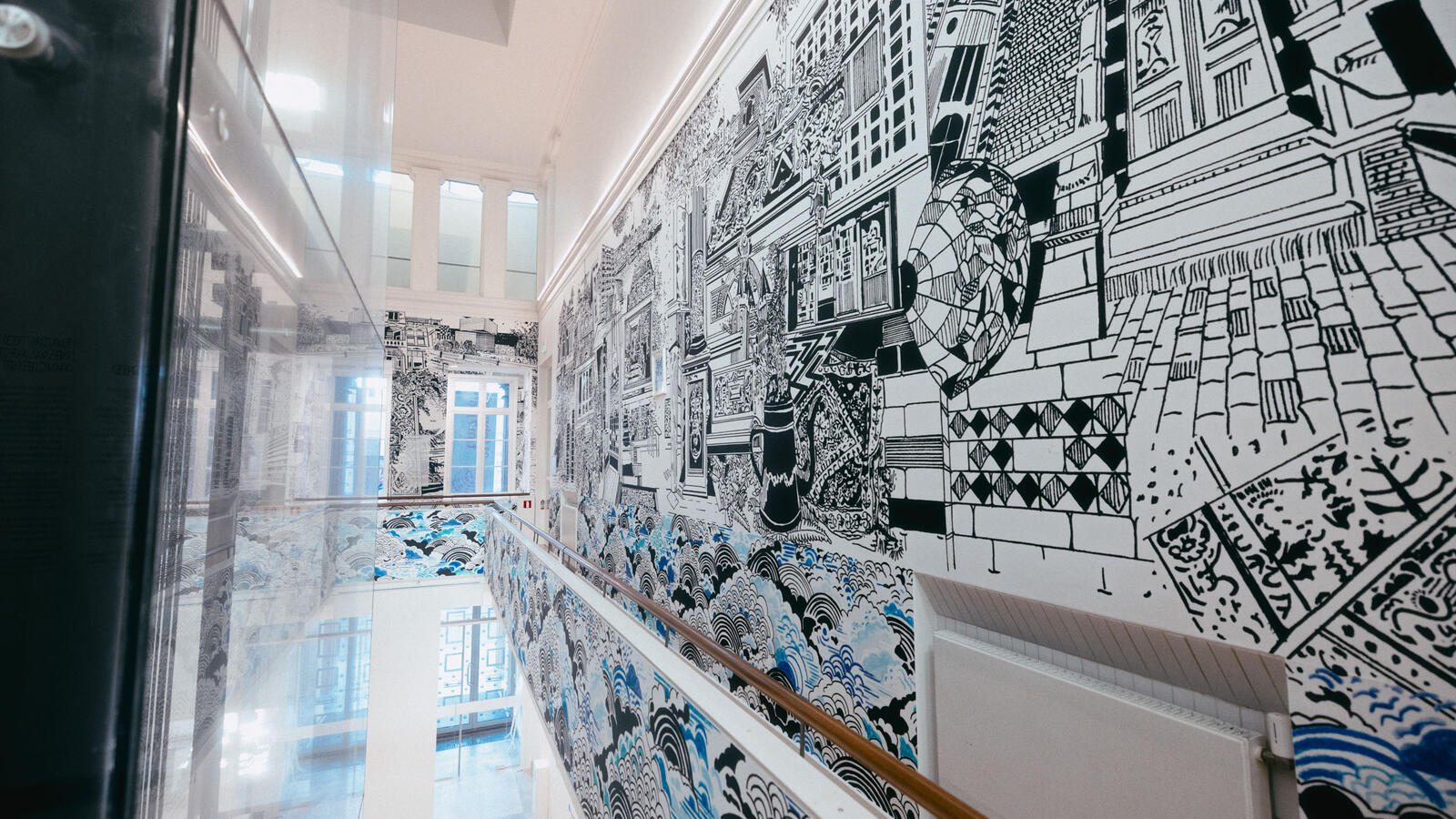 De balustrade van de Fundatie, met rechts een grote muur illustratie in zwart-wit en blauw