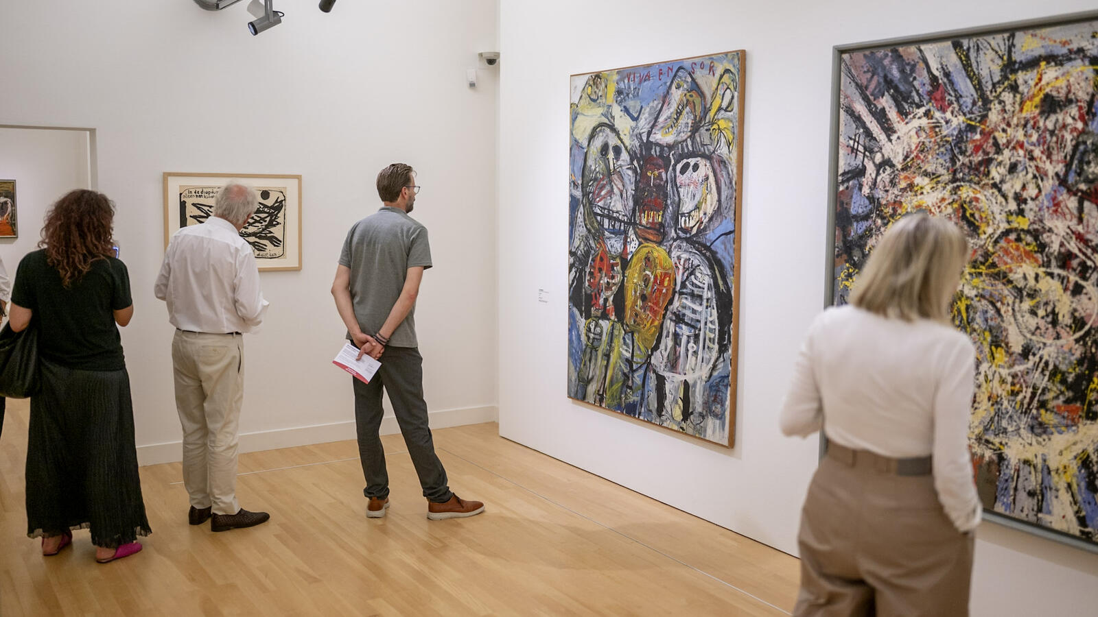 een overzichtsfoto van een van de zalen uit de tentoonstelling Cremer in Context met verschillende mensen die in de zaal rondlopen