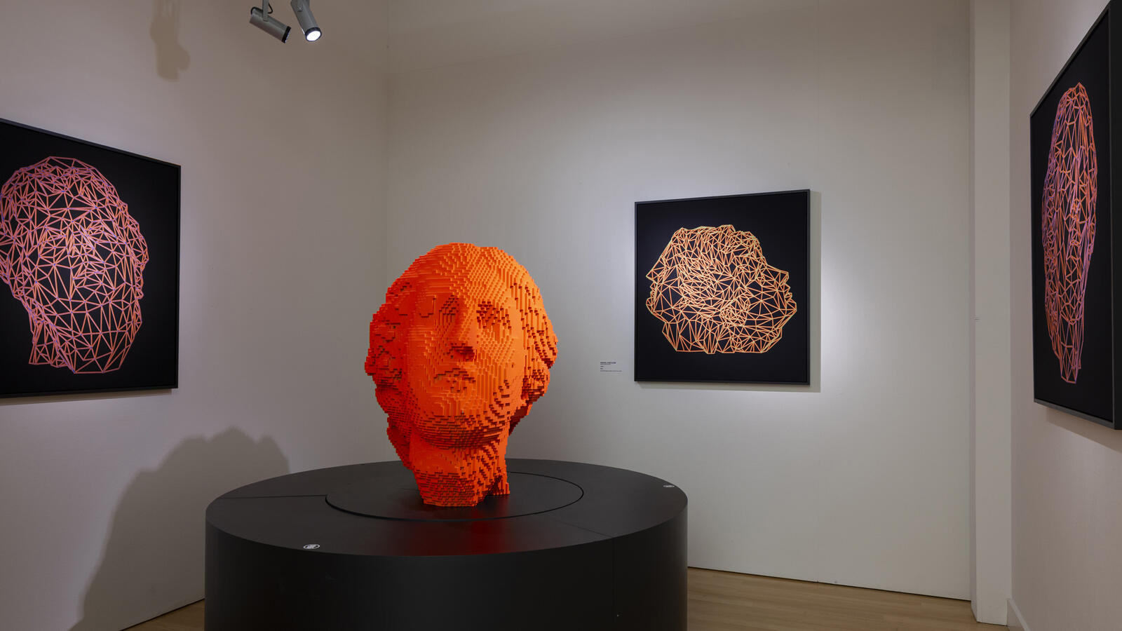 een 3d werk van Miguel Chevalier, een oranje hoofd die bestaat uit pixels