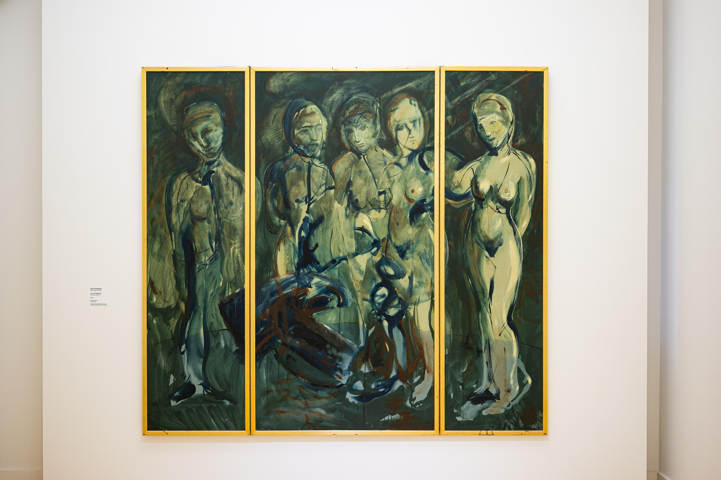 Een panelschilderij in donkergroene tinten van naakte vrouwen hangt aan de muur. 