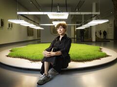 Diana Scherer sitting in front of one of her works